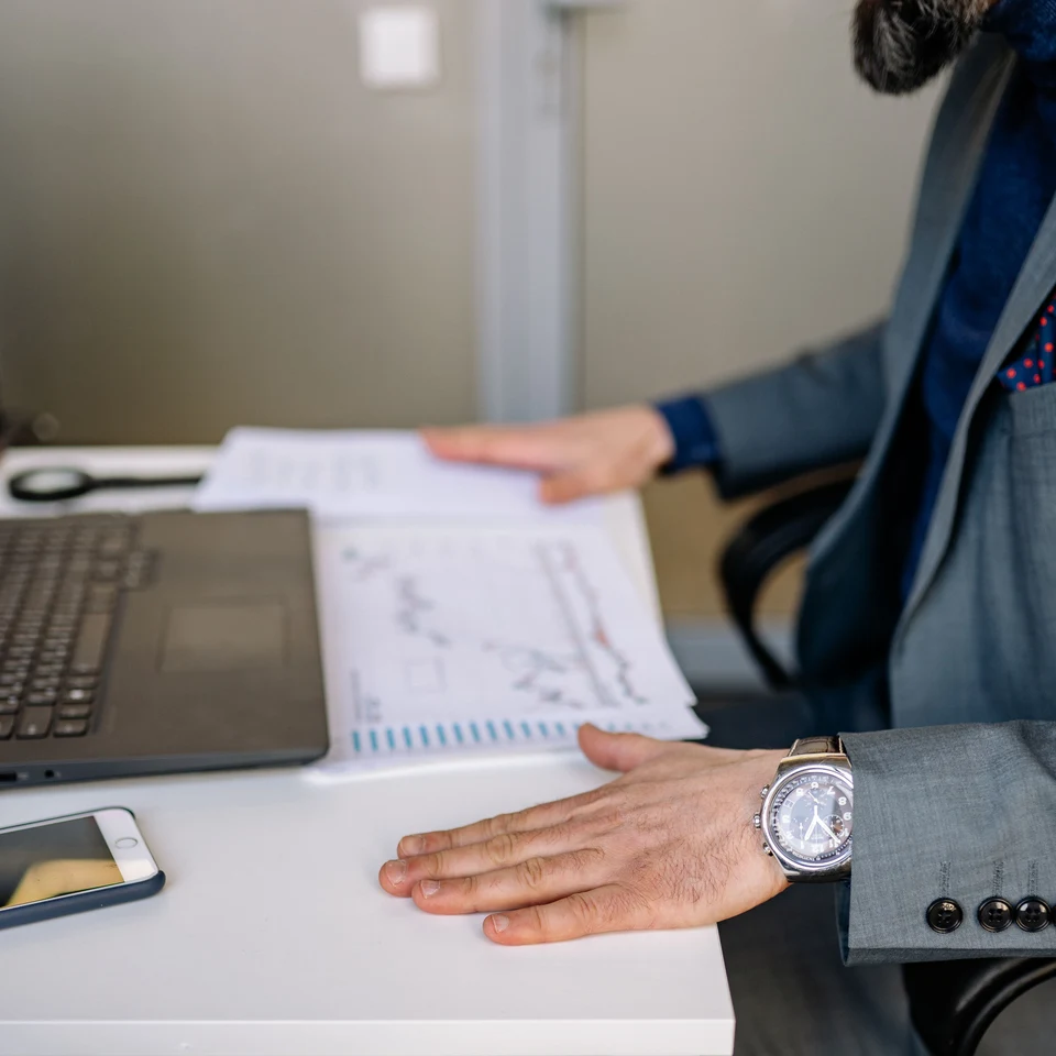 A business owner reviewing revenue and cash flow charts on a laptop while preparing to apply for funding